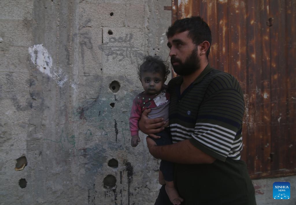 A man holds a injured child after Israeli airstrikes in the southern Gaza Strip city of Rafah, on Oct. 17, 2023. The number of Palestinian deaths caused by Israeli airstrikes in Gaza has risen to 3,000, according to the Gaza-based Health Ministry. The Israeli airstrikes were triggered by a large-scale Hamas attack on Israeli military targets and towns on Oct. 7, which has so far killed at least 1,300 people in Israel.(Photo: Xinhua)