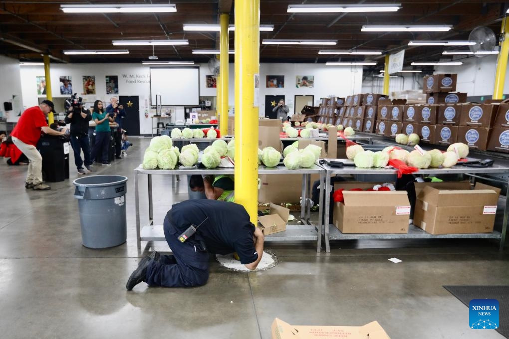 People do a Drop, Cover, and Hold On earthquake drill at the L.A. Regional Food Bank in Los Angeles, California, the United States, on Oct. 19, 2023. An annual earthquake drill was held across the United States on Thursday, in an aim to help people better protect themselves during earthquakes.(Photo: Xinhua)