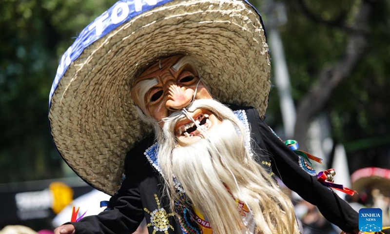 A masked person takes part in the Monumental Alebrijes Parade 2023 in Mexico City, capital of Mexico, Oct. 21, 2023. Alebrijes are brightly colored folk art sculptures of fantastical creatures. (Photo: Xinhua)