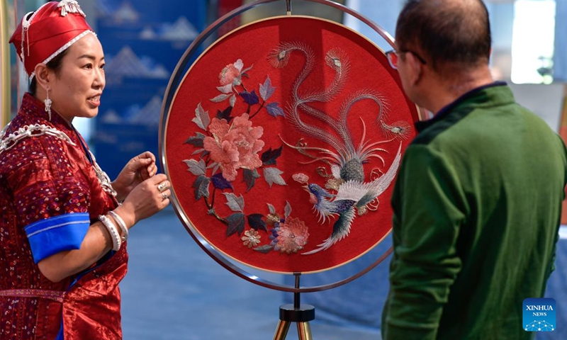 Long Luying discusses design solutions of Miao embroidery decorations with her husband at the workshop in Shibing County of Qiandongnan Miao and Dong Autonomous Prefecture, southwest China's Guizhou Province, Oct. 18, 2023. (Photo: Xinhua)