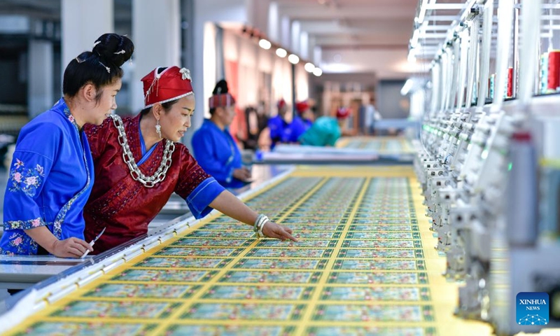 Long Luying (2nd L) and her employee check Miao embroidery products at the workshop in Shibing County of Qiandongnan Miao and Dong Autonomous Prefecture, southwest China's Guizhou Province, Oct. 18, 2023. (Photo: Xinhua)