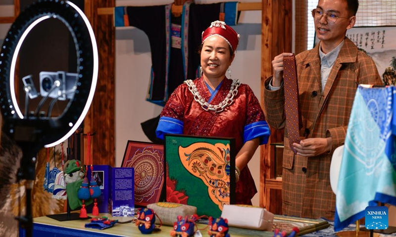 Long Luying (L) and her son promote Miao embroidery products via livestreaming in Shibing County of Qiandongnan Miao and Dong Autonomous Prefecture, southwest China's Guizhou Province, Oct. 18, 2023. (Photo: Xinhua)