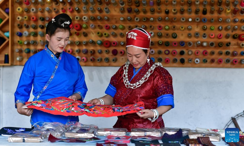 Long Luying (R) and her employee check the quality of Miao embroidery products at the workshop in Shibing County of Qiandongnan Miao and Dong Autonomous Prefecture, southwest China's Guizhou Province, Oct. 18, 2023. (Photo: Xinhua)