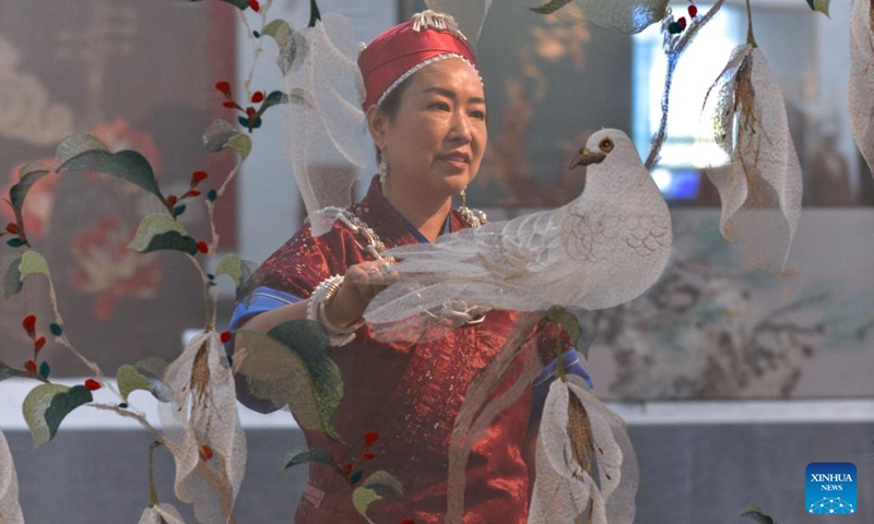 Long Luying checks Miao embroidery decorations at the workshop in Shibing County of Qiandongnan Miao and Dong Autonomous Prefecture, southwest China's Guizhou Province, Oct. 18, 2023. (Photo: Xinhua)