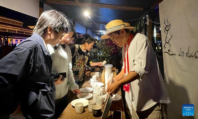 Park Ju-hee presents her creations to customers at a stand during an open-air art fair, as part of the 2023 China Jingdezhen International Ceramic Expo, in Jingdezhen, east China's Jiangxi Province, Oct. 18, 2023. (Photo: Xinhua)