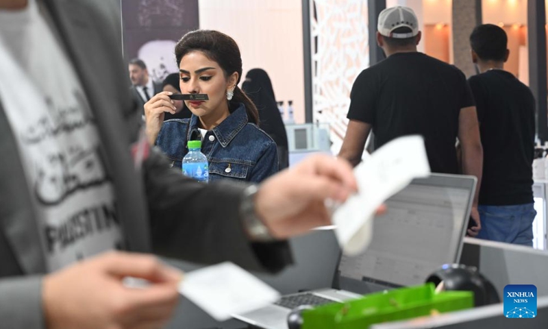 A woman tries a perfume at a perfumes exhibition in Hawalli Governorate, Kuwait, on Oct. 24, 2023. The perfumes exhibition is opened here on Tuesday and will last until Nov. 4.(Photo: Xinhua)