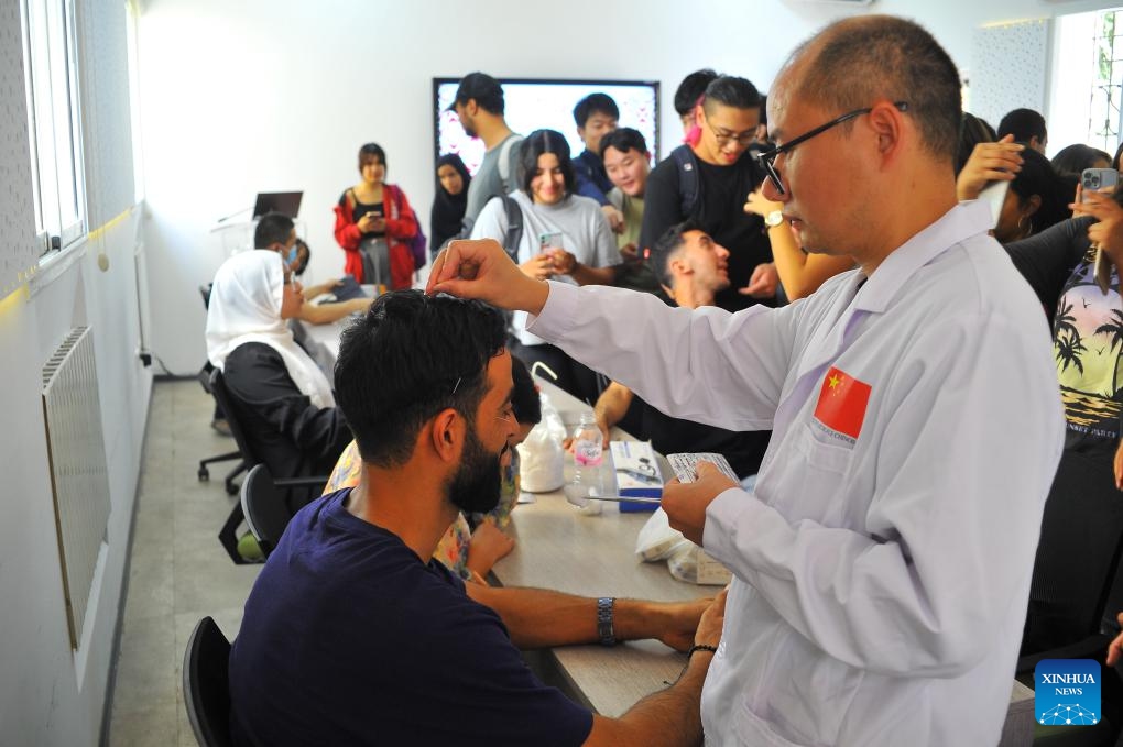 A Chinese doctor from the 27th batch of the Chinese medical team to Tunisia provides free acupuncture treatment for teachers and students at the Confucius Institute of the University of Carthage in Tunis, Tunisia, Oct. 23, 2023.(Photo: Xinhua)