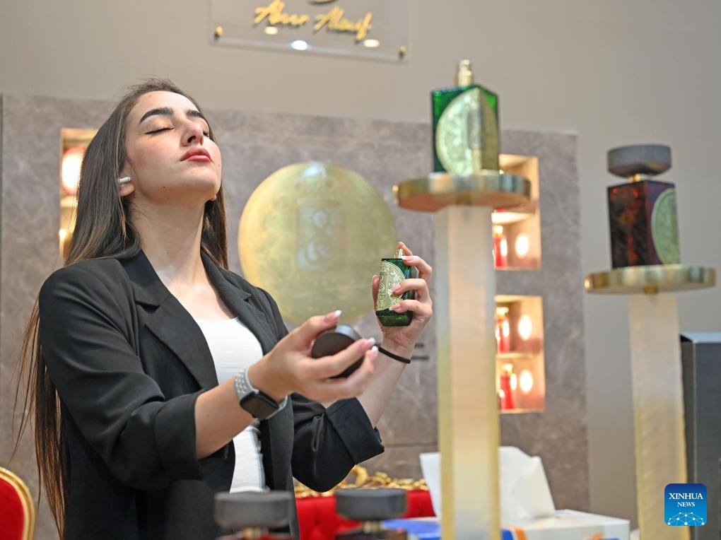 A woman tries a perfume at a perfumes exhibition in Hawalli Governorate, Kuwait, on Oct. 24, 2023. The perfumes exhibition is opened here on Tuesday and will last until Nov. 4.(Photo: Xinhua)