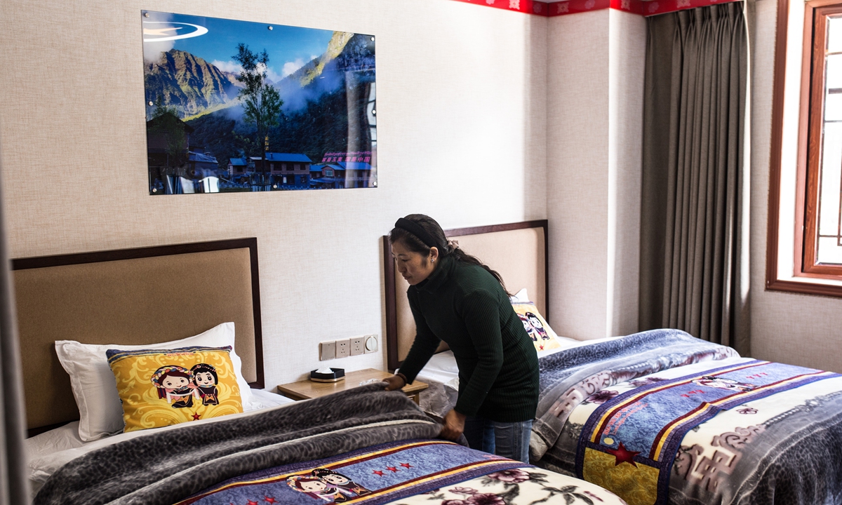 A woman makes a bed in her family inn in Yumai on October 25, 2023. Photo: Shan Jie/GT