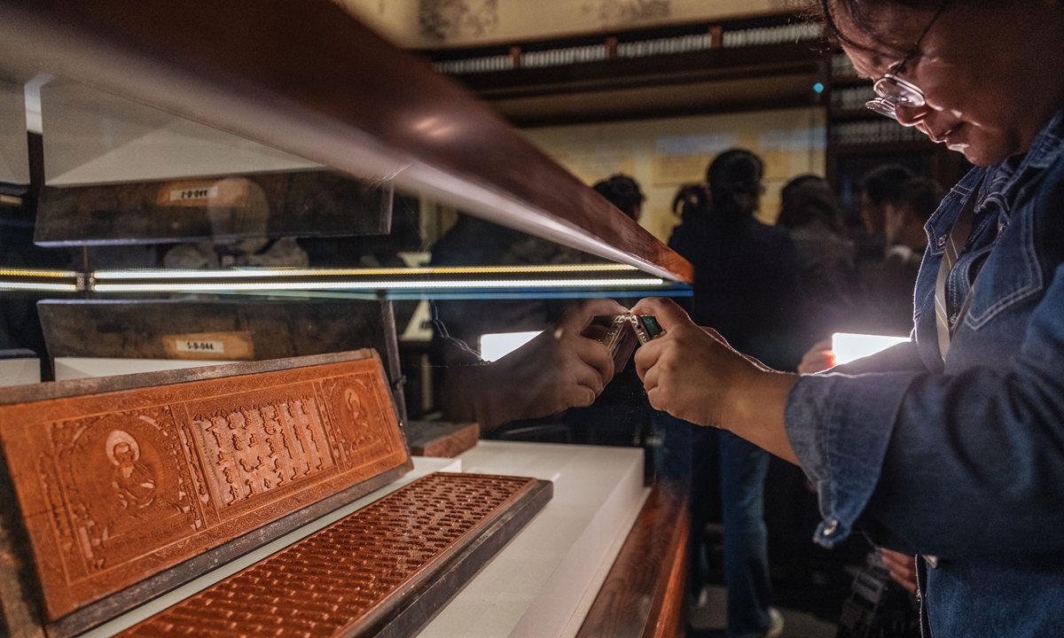 A visitor takes a photo of a cultural relic at the newly opened Engravings Hall at the Palace Museum in Beijing on October 30, 2023. The Palace Museum opened the hall on Monday and held an exhibition of Qing Dynasty palace engravings, displaying over 15,000 artifacts. Photo: VCG