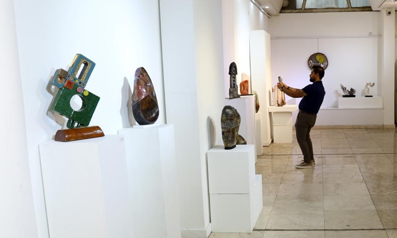 A visitor takes photos of ceramic works at a ceramics exhibition organized by Iraqi Plastic Artists Society in Baghdad, Iraq, Oct. 28, 2023. (Photo: Xinhua)