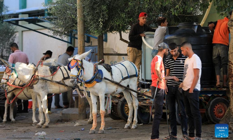 People use donkey-drawn carts to transport water in the southern Gaza Strip city of Khan Younis on Oct. 30, 2023. The Palestinian Islamic Resistance Movement (Hamas) launched a surprise attack on Israel on Oct. 7, firing thousands of rockets and infiltrating Israeli territory, to which Israel responded with massive airstrikes and punitive measures, including a siege on the enclave with supplies of water, electricity, fuel, and other necessities being cut off.(Photo: Xinhua)