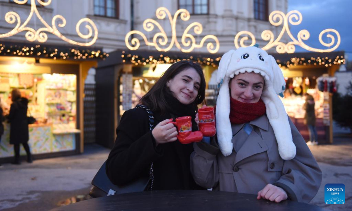 People pose for a photo at the Christmas market of Belvedere, Vienna, Austria, Nov 17, 2023. Photo:Xinhua