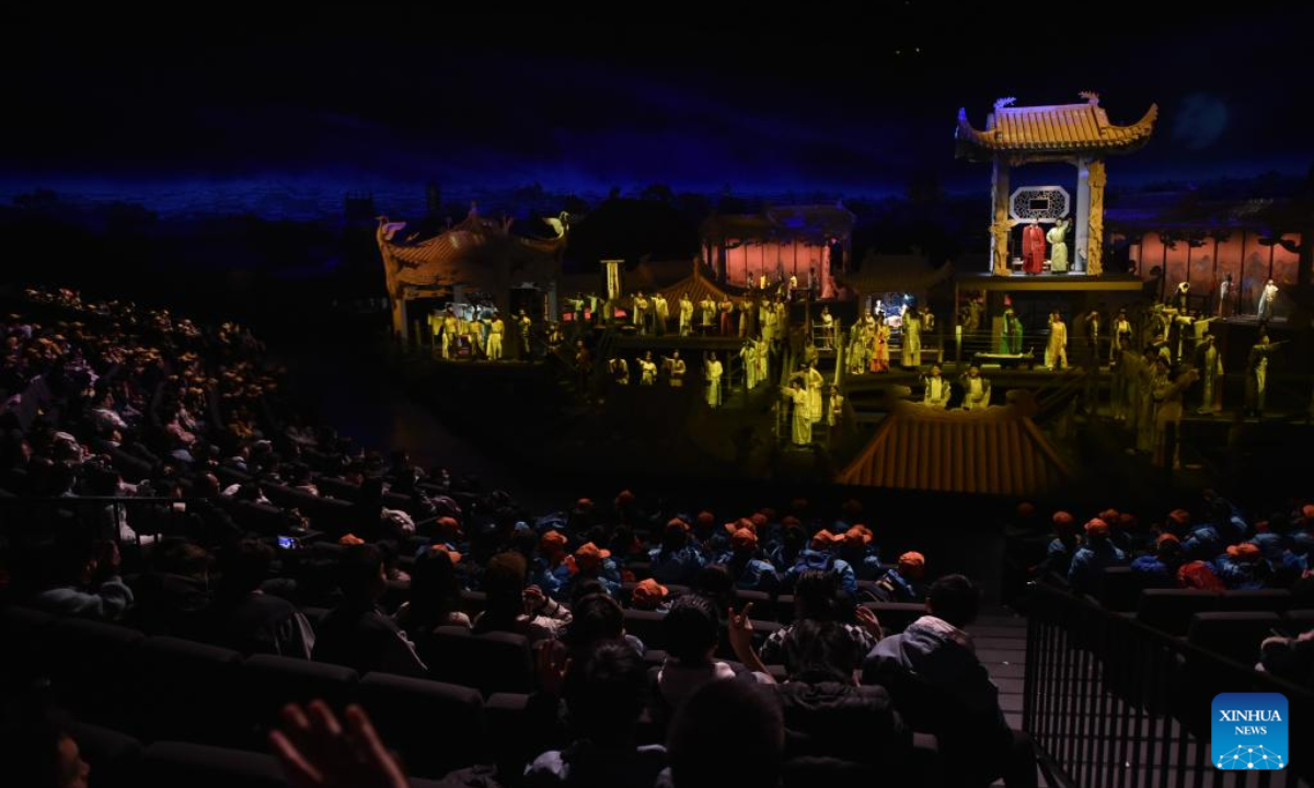 Tourists enjoy a performance at 