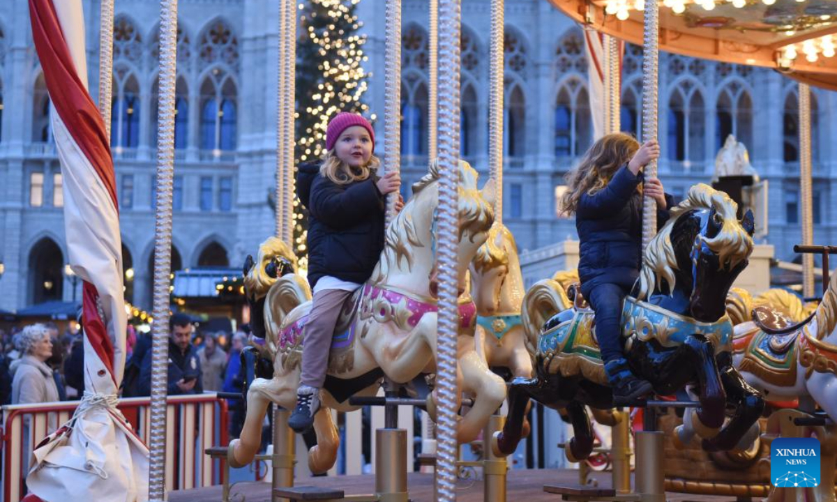 Children enjoy carousel at a Christmas market in Vienna's Rathausplatz, Austria, Nov 16, 2023. Photo:Xinhua