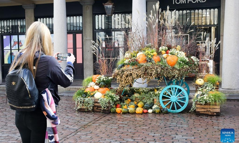 A woman takes photos of Halloween display in Covent Garden in London, Britain, Oct. 30, 2023.(Photo: Xinhua)