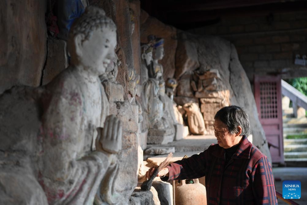 A volunteer cleans up a statue at a cultural relics protection site of Dazu Rock Carvings in Zhongao Town of Dazu District, southwest China's Chongqing Municipality, Oct. 31, 2023. Dazu Rock Carvings originated from Sichuan and Chongqing regions in ancient China. In 1999, the carvings were added to the UNESCO World Heritage List as a cultural heritage site.(Photo: Xinhua)