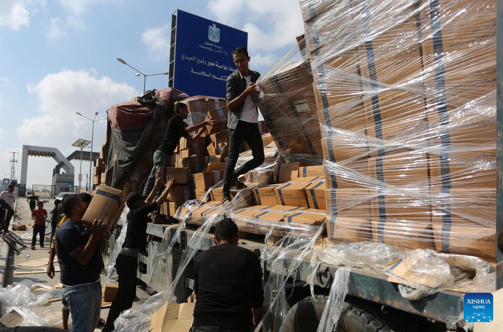 People unload humanitarian aid from a truck at the Rafah crossing in the southern Gaza Strip, on Nov. 2, 2023. A convoy of 73 trucks carrying humanitarian aid supplies is entering the besieged Gaza Strip, and hundreds of more evacuees are expected to arrive in Egypt via the Rafah border crossing on Thursday, an Egyptian source told Xinhua on the condition of anonymity.(Photo: Xinhua)