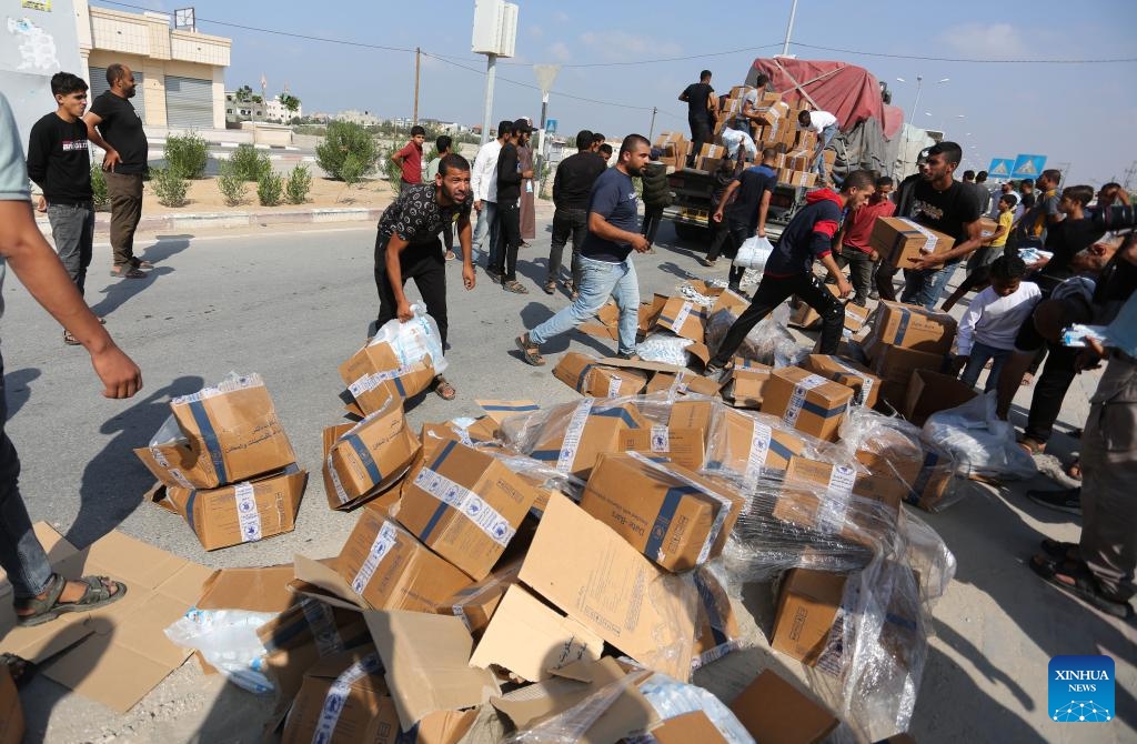 People unload humanitarian aid from a truck at the Rafah crossing in the southern Gaza Strip, on Nov. 2, 2023. A convoy of 73 trucks carrying humanitarian aid supplies is entering the besieged Gaza Strip, and hundreds of more evacuees are expected to arrive in Egypt via the Rafah border crossing on Thursday, an Egyptian source told Xinhua on the condition of anonymity.(Photo: Xinhua)