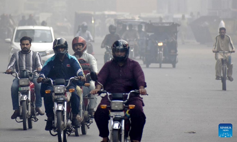 People drive on a road during smog in Lahore, Pakistan on Nov. 2, 2023. The government in Pakistan's Punjab province has imposed a smog emergency in the province, local media reported.(Photo: Xinhua)