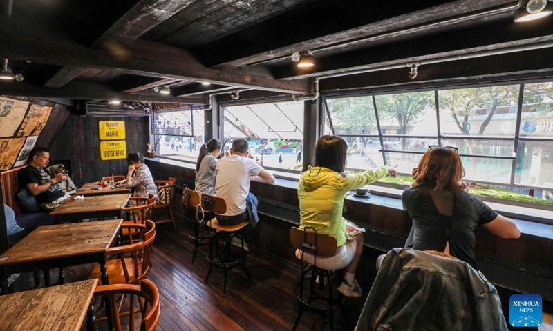 People are seen at a cafe in Shanghai, east China, Nov. 3, 2023. The 6th China International Import Expo (CIIE) is scheduled to be held in Shanghai from Nov. 5 to 10. The expo showcases China's new development paradigm, a platform for high-standard opening up, and a public good for the whole world. (Photo: Xinhua)