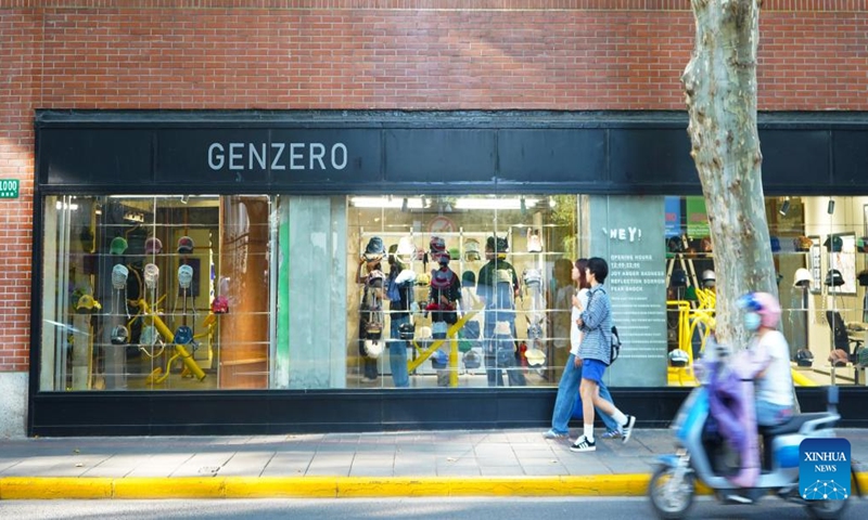 People walk past a garment store in Shanghai, east China, Nov. 3, 2023. The 6th China International Import Expo (CIIE) is scheduled to be held in Shanghai from Nov. 5 to 10. The expo showcases China's new development paradigm, a platform for high-standard opening up, and a public good for the whole world. (Photo: Xinhua)