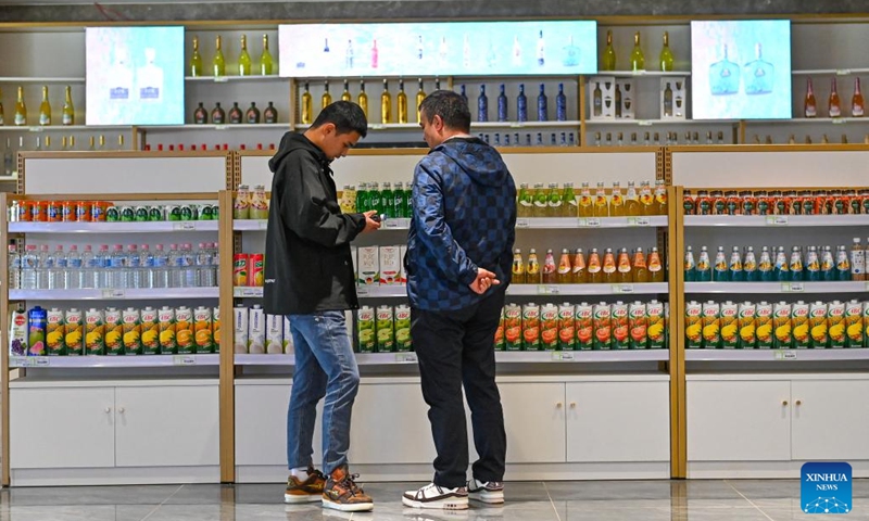 Customers select commodities at the cross-border e-commerce import and export commodities exhibition and trading center in the comprehensive bonded zone in Kashgar Prefecture, northwest China's Xinjiang Uygur Autonomous Region, Nov. 4, 2023. (Photo: Xinhua)