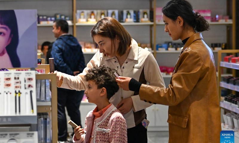 Customers select commodities at the cross-border e-commerce import and export commodities exhibition and trading center in the comprehensive bonded zone in Kashgar Prefecture, northwest China's Xinjiang Uygur Autonomous Region, Nov. 4, 2023. (Photo: Xinhua)