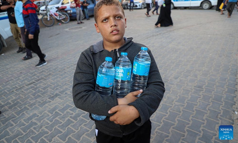 A boy holds bottles of water he got from supplies in the southern Gaza Strip city of Khan Younis Nov. 4, 2023. (Photo: Xinhua)