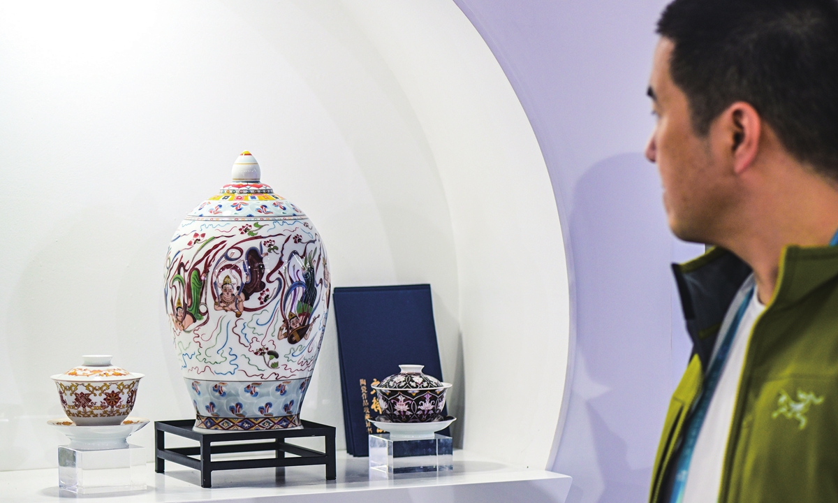 A visitor looks at porcelain pieces on display at the Jingdezhen booth at the CIIE in Shanghai on November 8, 2023. Jingdezhen, a world-famous 