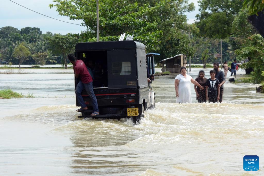 People wade through a flooded road in Gampaha, Sri Lanka, on Nov. 8, 2023. Most of the areas in Gampaha district are flooded due to heavy rains in the past few days.(Photo: Xinhua)