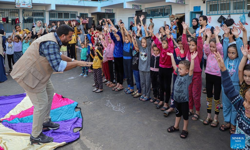 A volunteer interacts with children during a psychological stimulation and relief activity at a school affiliated to the United Nations Relief and Works Agency for Palestine Refugees (UNRWA) in the southern Gaza Strip city of Khan Younis, Nov. 8, 2023. UN Secretary-General Antonio Guterres said Monday that the unfolding catastrophe in Gaza makes a humanitarian cease-fire more urgent with every passing hour.(Photo: Xinhua)