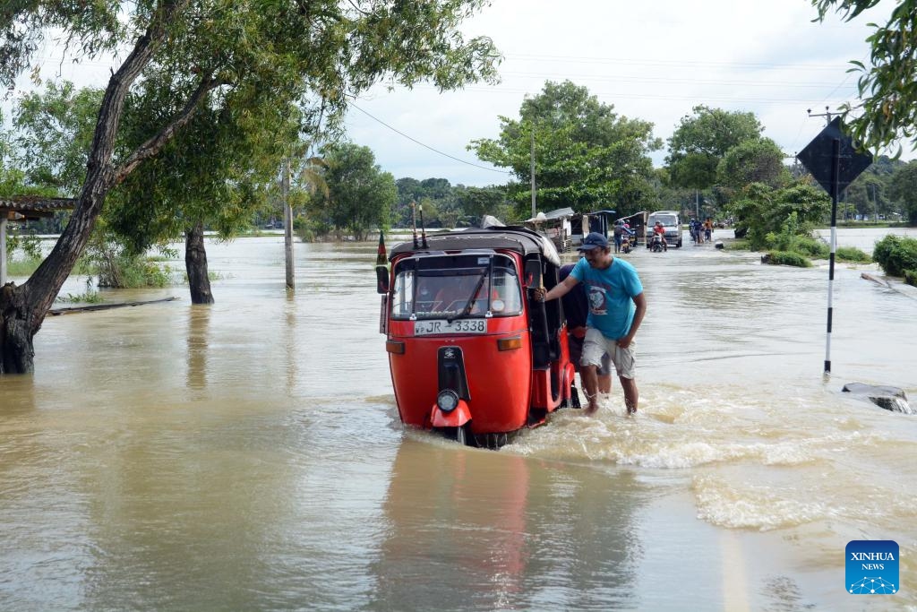 People wade through a flooded road in Gampaha, Sri Lanka, on Nov. 8, 2023. Most of the areas in Gampaha district are flooded due to heavy rains in the past few days.(Photo: Xinhua)