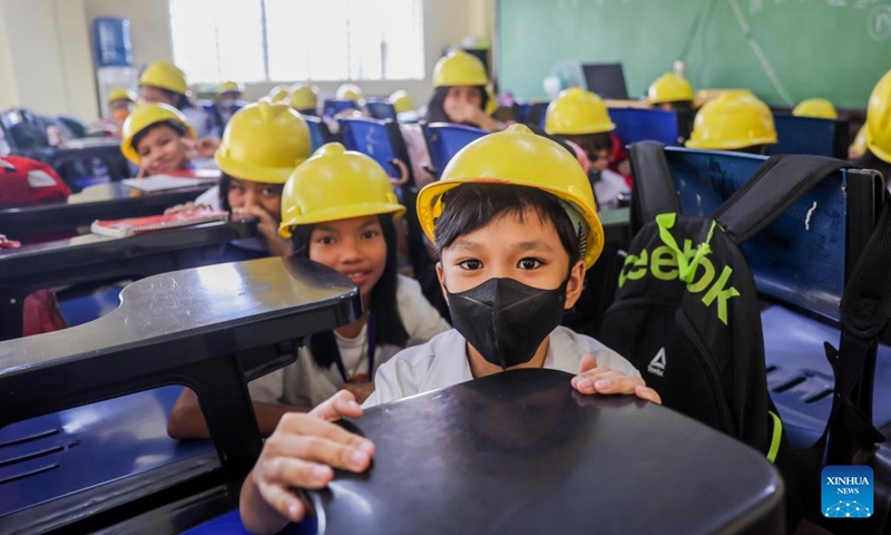 Students wearing hard hats participate in a nationwide simultaneous earthquake drill at a school in Quezon City, the Philippines, Nov. 9, 2023.(Photo: Xinhua)