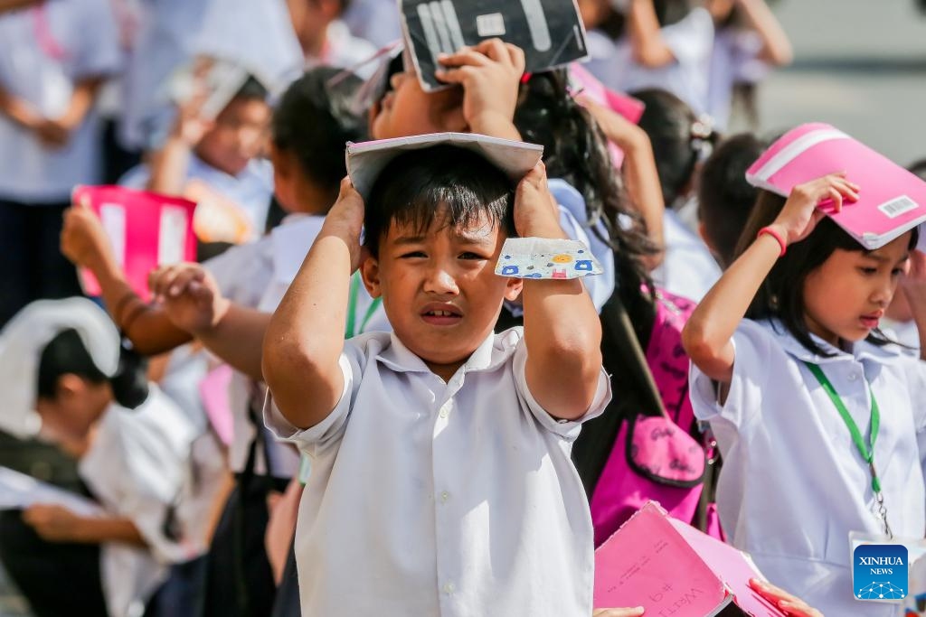 Students cover their heads during a nationwide simultaneous earthquake drill at a school in Quezon City, the Philippines, Nov. 9, 2023.(Photo: Xinhua)