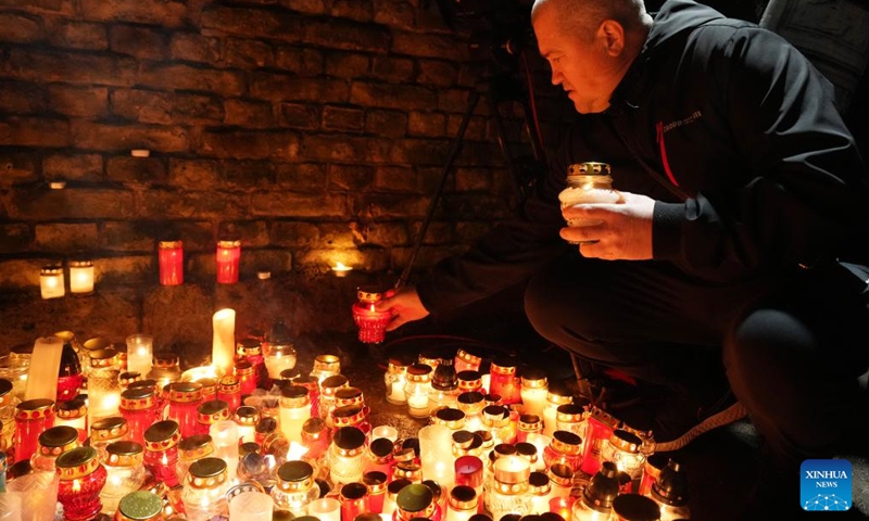 A man lights candles during an event to mark the Latvian Freedom Fighters Remembrance Day, or Lacplesis Day, in Riga, Latvia, Nov. 11, 2023. (Photo: Xinhua)