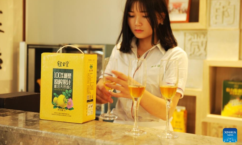 A worker shows a Cili beverage at a Cili processing company in Longli County, southwest China's Guizhou Province, Aug. 23, 2018. (Photo: Xinhua)