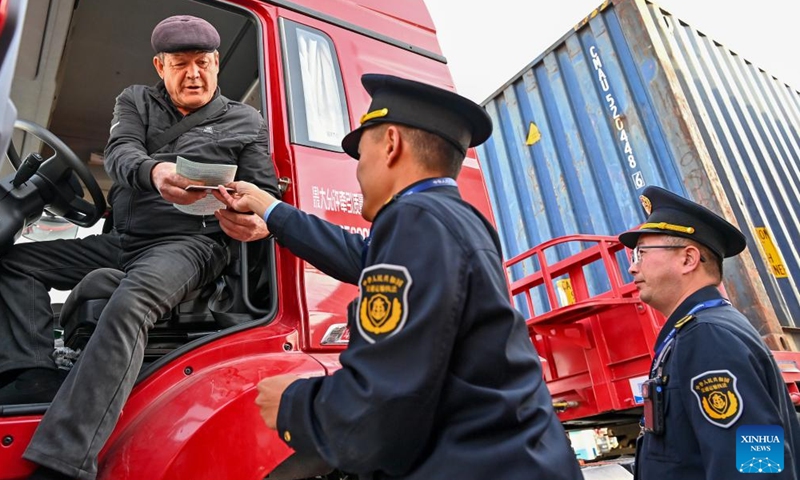 Staff members check the credentials of a vehicle driving outbound at the Irkeshtam port in northwest China's Xinjiang Uygur Autonomous Region, Nov. 8, 2023. (Photo: Xinhua)