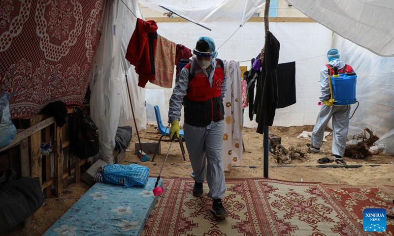 Staff workers disinfect a temporary shelter in the southern Gaza Strip city of Khan Younis, on Nov. 12, 2023. (Photo: Xinhua)