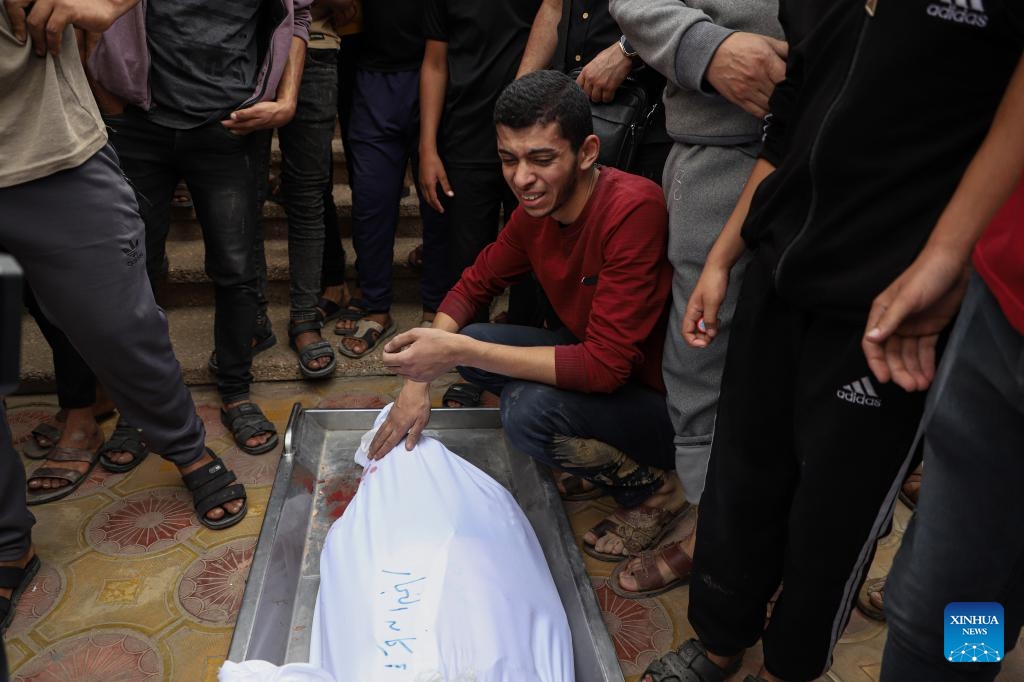 A man mourns for a victim of the Palestinian-Israeli conflict in the southern Gaza Strip city of Khan Younis on Nov. 12, 2023. The government media office in Gaza on Sunday announced that the casualties from Israeli attacks climbed to 11,180, including nearly 8,000 children and women, with more than 28,000 injuries.(Photo: Xinhua)