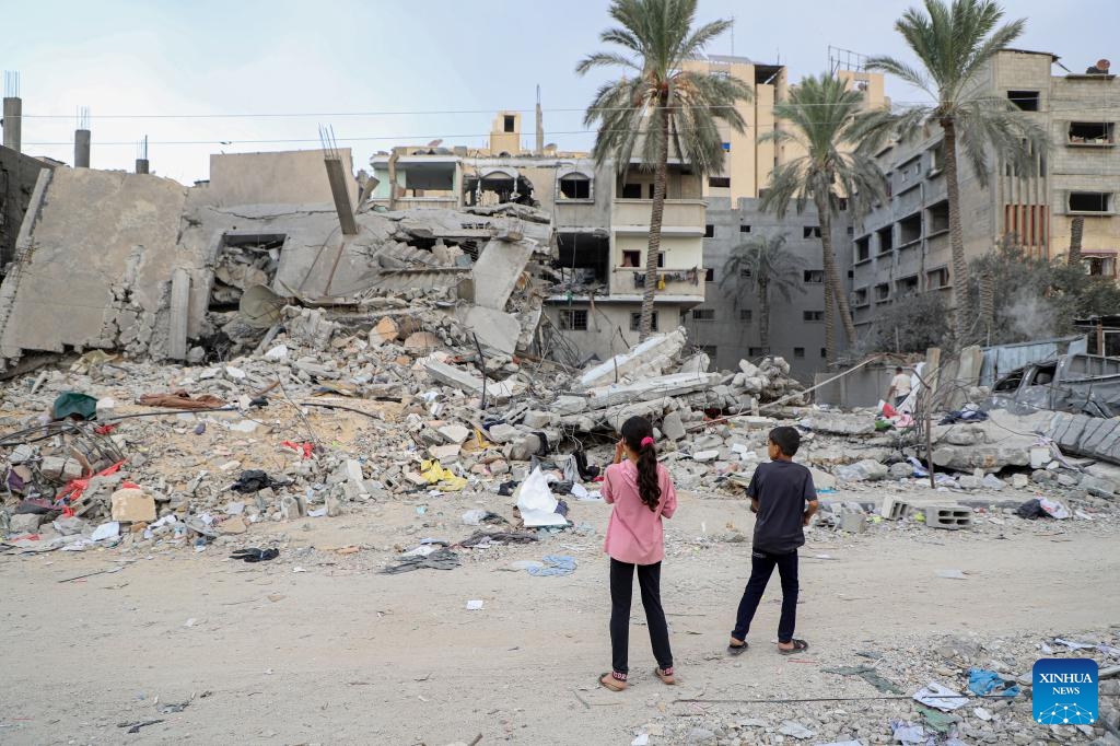 Children stand beside the rubble of buildings destroyed in Israeli airstrikes in the southern Gaza Strip city of Khan Younis on Nov. 12, 2023. The government media office in Gaza on Sunday announced that the casualties from Israeli attacks climbed to 11,180, including nearly 8,000 children and women, with more than 28,000 injuries.(Photo: Xinhua)