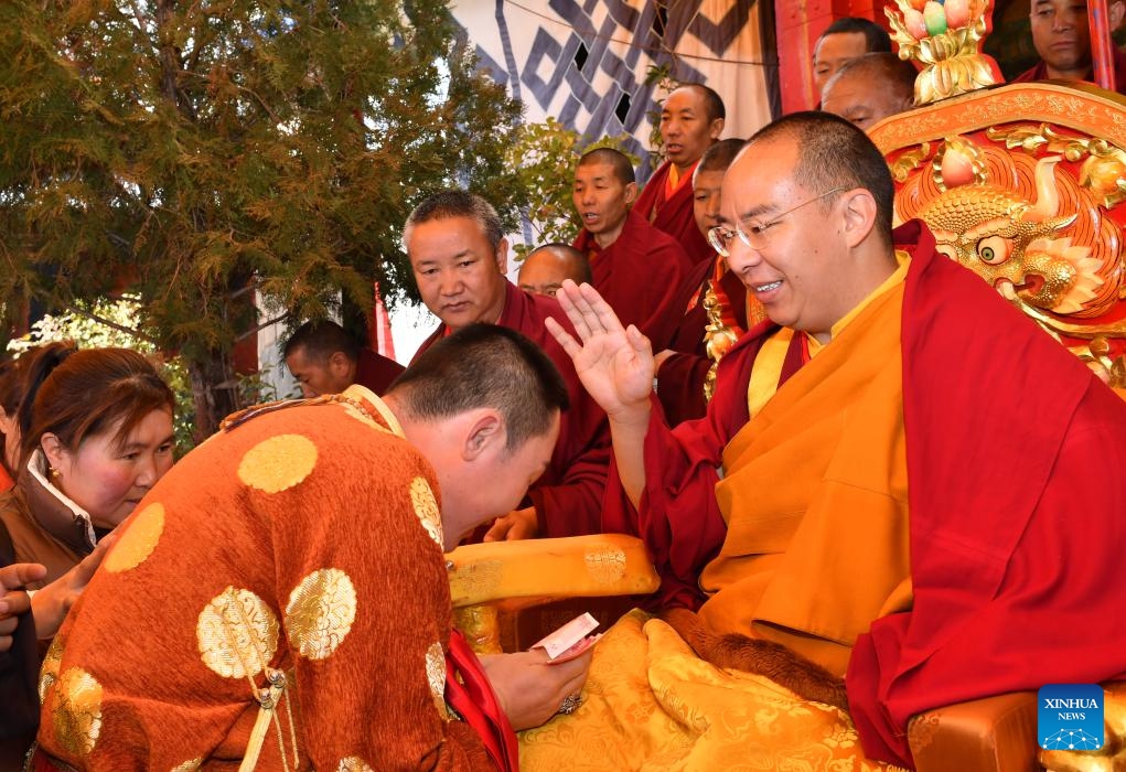 Panchen Erdeni Chos-kyi rGyal-po carries out a head-touching ceremony to bless Buddhist adherents in the city of Xigaze, southwest China's Xizang Autonomous Region, Nov. 14, 2023.(Photo: Xinhua)