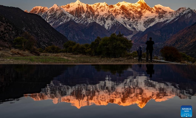 This photo taken on Nov. 13, 2023 shows the sunset scenery of Mount Namcha Barwa seen at Suosong Village of Nyingchi, southwest China's Tibet Autonomous Region.(Photo: Xinhua)