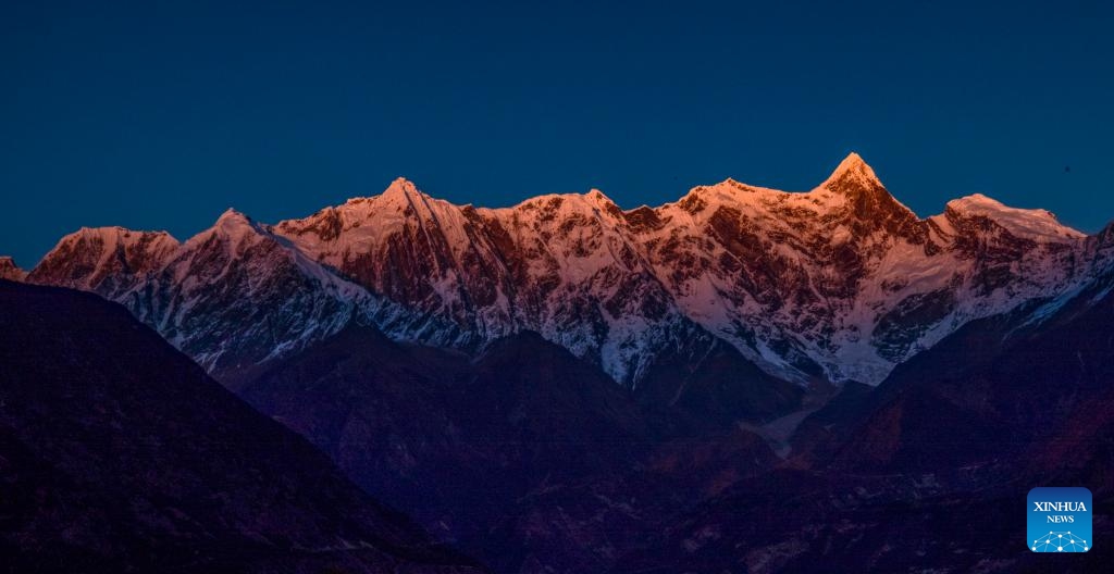 This photo taken on Nov. 13, 2023 shows the sunset scenery of Mount Namcha Barwa seen at Suosong Village of Nyingchi, southwest China's Tibet Autonomous Region.(Photo: Xinhua)