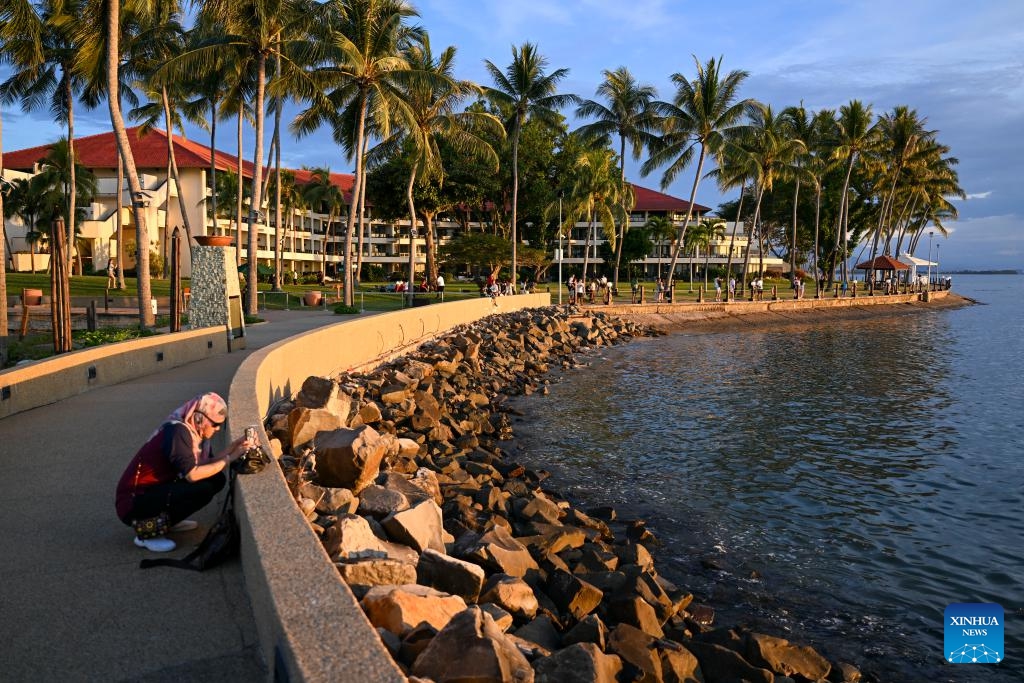 A woman takes photos of the sunset near seaside in Kota Kinabalu, Sabah, Malaysia, Nov. 14, 2023.(Photo: Xinhua)