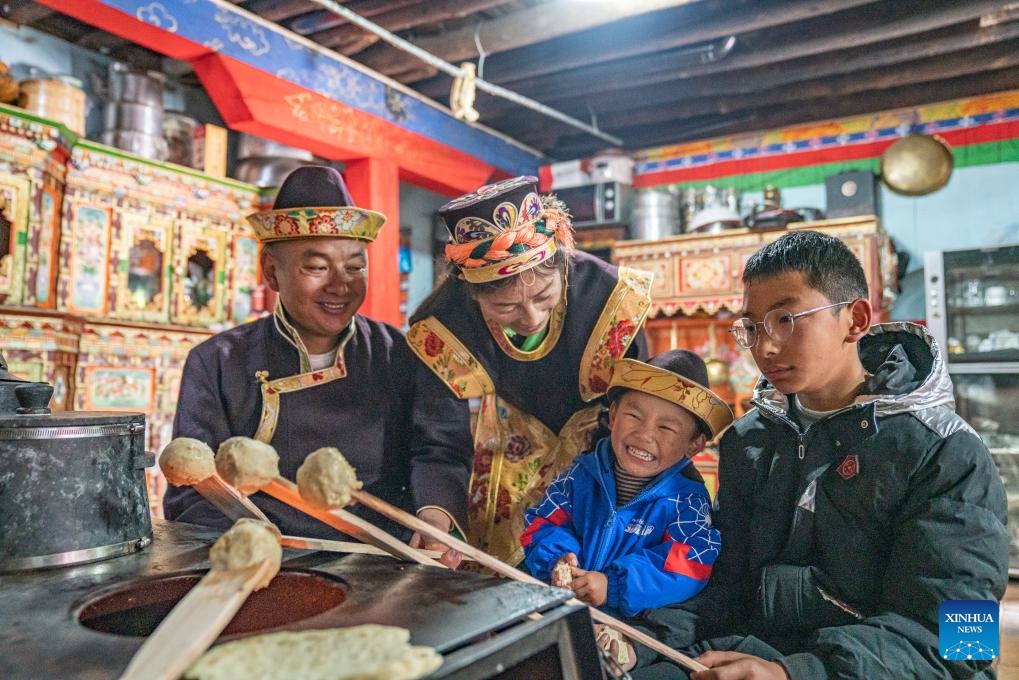 Tsering Toinzhub (1st L) and Lhagba Zhoima (2nd L) enjoy traditional food with their family in Suosong Village of Nyingchi, southwest China's Xizang Autonomous Region, Nov. 14, 2023. Locals in Nyingchi follow the tradition to celebrate their special New Year, known as the Gongbo New Year, on Oct. 1 by the Tibetan calendar, which fell on Nov. 14 this year.(Photo: Xinhua)