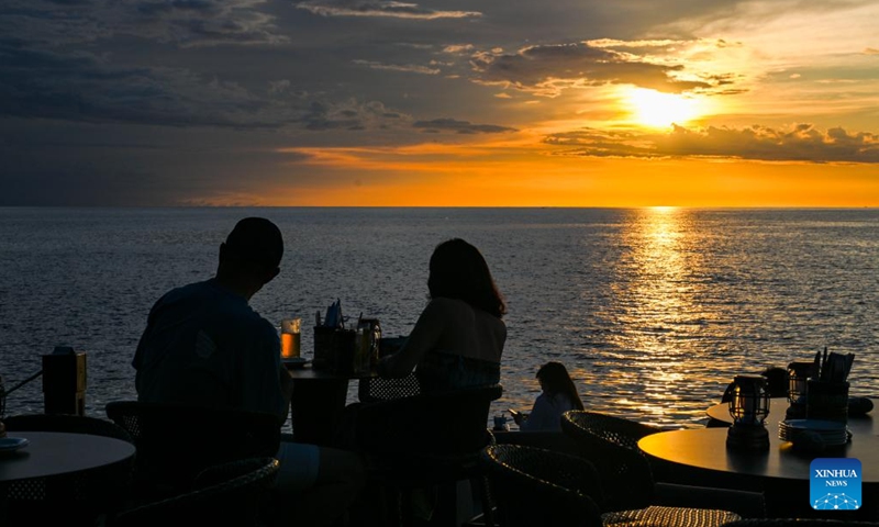 People enjoy the sunset at a cafe near seaside in Kota Kinabalu, Sabah, Malaysia, Nov. 14, 2023.(Photo: Xinhua)