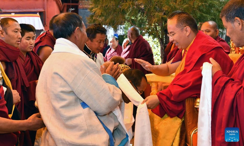 Panchen Erdeni Chos-kyi rGyal-po carries out a head-touching ceremony to bless Buddhist adherents in the city of Xigaze, southwest China's Xizang Autonomous Region, Nov. 14, 2023.(Photo: Xinhua)