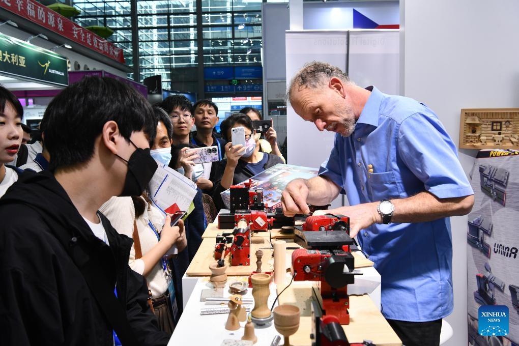 People learn about a mini-lathe at the exhibition booth of Bavaria during the 25th China Hi-Tech Fair (CHTF) in Shenzhen, south China's Guangdong Province, Nov. 15, 2023. The 25th China Hi-Tech Fair (CHTF) kicked off here Wednesday, attracting 4,925 exhibitors from 105 countries and regions.(Photo: Xinhua)