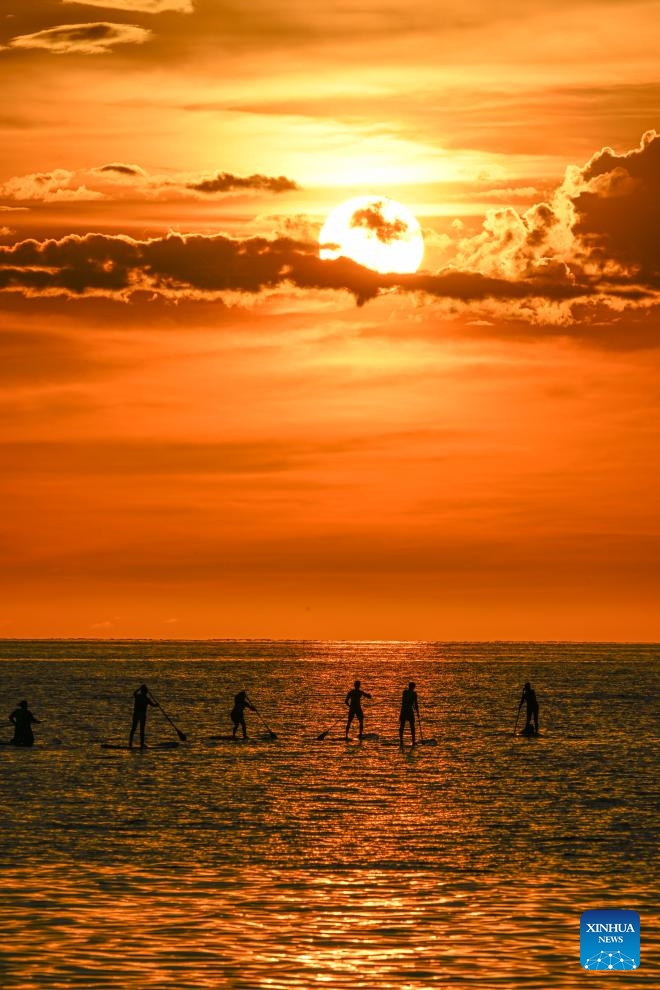 People enjoy themselves on the sea at sunset in Kota Kinabalu, Sabah, Malaysia, Nov. 14, 2023.(Photo: Xinhua)